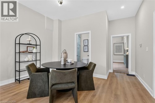 Open concept room featuring light wood-finish flooring, crisp white baseboards, and light gray walls - 118 Cathcart Street, Hamilton, ON 