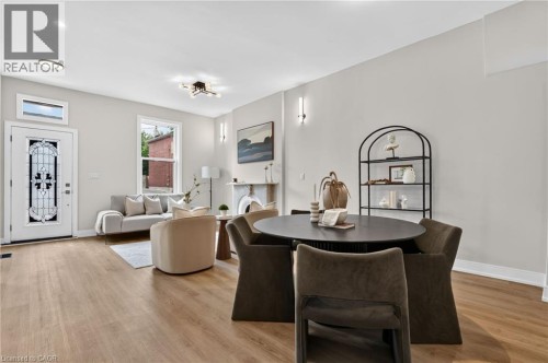 Open-concept living space featuring wood-finish flooring, recessed lighting, and a decorative fireplace - 118 Cathcart Street, Hamilton, ON 