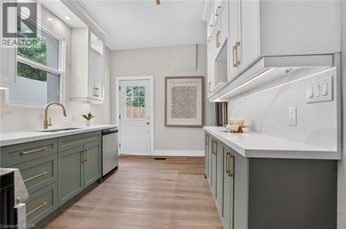 Contemporary kitchen featuring two-tone cabinetry, white countertops, and a full-height backsplash - 118 Cathcart Street, Hamilton, ON 