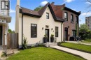 Cream stucco facade with dark trim accents and a contrasting brick party wall - 118 Cathcart Street, Hamilton, ON 