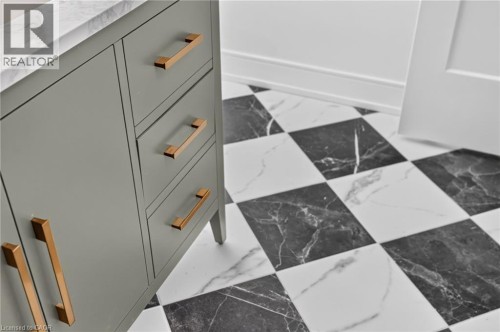 Gray vanity with a stone countertop and gold-toned hardware - 118 Cathcart Street, Hamilton, ON 