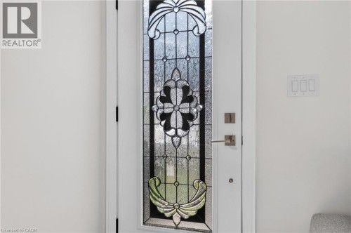 Entry door with leaded glass panel featuring intricate decorative patterns - 118 Cathcart Street, Hamilton, ON 