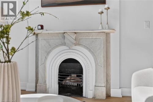 Ornate fireplace featuring a carved marble surround, arched opening, and a dark firebox with a metal grate - 118 Cathcart Street, Hamilton, ON 