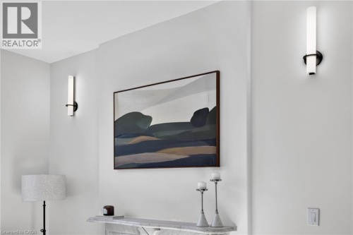 Contemporary wall sconces illuminating a light-toned interior wall, featuring a built-in shelf with a stone-like finish - 118 Cathcart Street, Hamilton, ON 