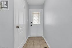 Entryway featuring a white door with decorative glass inserts and a keyless entry system - 