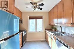 Kitchen featuring extensive wood-finish cabinetry, a dual basin stainless steel sink, and a built-in dishwasher - 