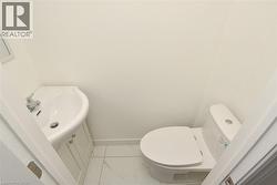 Compact powder room featuring a corner vanity with chrome fixtures and a white toilet - 