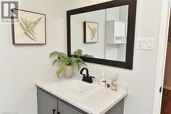 Vanity featuring a white countertop with integrated sink, dark gray cabinetry, and matte black faucet - 