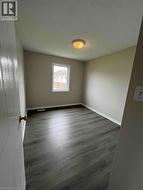 Room featuring dark wood-finish flooring, neutral wall tones, and white trim - 