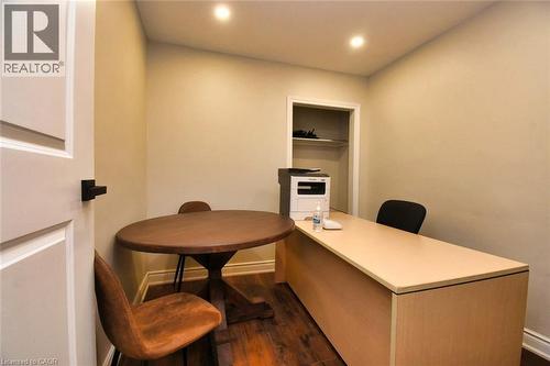 Versatile room with recessed lighting, wood-finish flooring, a built-in closet with shelving, and a panel door with matte black hardware - 242 James Street S, Hamilton, ON 