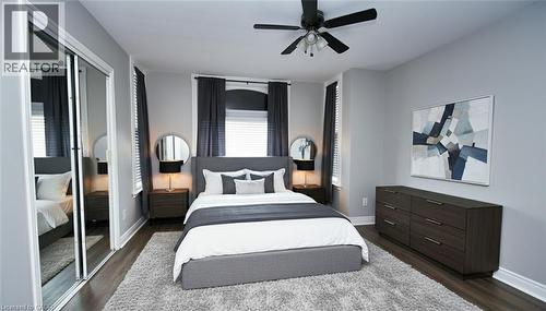 Bedroom featuring wood-finish flooring, light grey walls, and a ceiling fan with integrated lighting - 242 James Street S, Hamilton, ON 