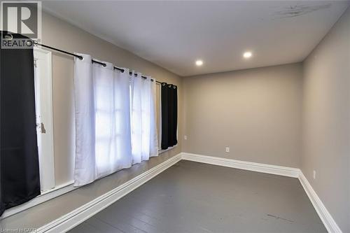 Room featuring painted flooring, neutral wall tones, and recessed ceiling lighting - 242 James Street S, Hamilton, ON 