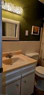 Bathroom with a single vanity, built-in sink, and white base cabinetry - 