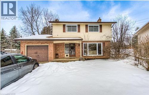 Two-story residence featuring a brick and siding exterior, an attached garage with a brown door, and a prominent front window - 110 Wren Place Unit# Upper, Kitchener, ON - Outdoor