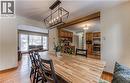 Dining area featuring wood-finish flooring, a contemporary linear chandelier, and a wood beam accent - 110 Wren Place Unit# Upper, Kitchener, ON  - Indoor Photo Showing Dining Room 