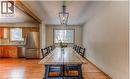 Kitchen and dining area featuring wood-finish flooring, stainless steel appliances, wood cabinetry, and a dark metal linear pendant light fixture - 110 Wren Place Unit# Upper, Kitchener, ON  - Indoor Photo Showing Dining Room 
