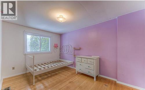 Bright interior room featuring wood-finish flooring, a large window, a ceiling-mounted light fixture, and a distinct accent wall - 110 Wren Place Unit# Upper, Kitchener, ON - Indoor Photo Showing Other Room