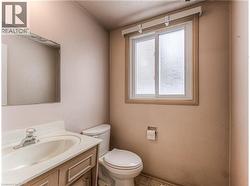 Bathroom featuring a white vanity with an integrated sink, polished chrome faucet, and a wall-mounted mirror - 
