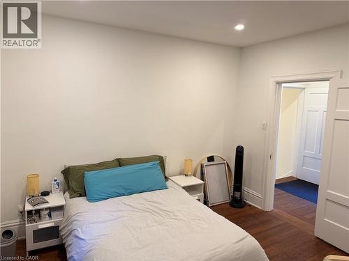 Room featuring wood-finish flooring, recessed lighting, and a white paneled door - 207 Charlton Avenue W, Hamilton, ON 