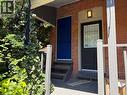 Brick facade featuring two entry doors, one in royal blue and one in black with a window - 207 Charlton Avenue W, Hamilton, ON 