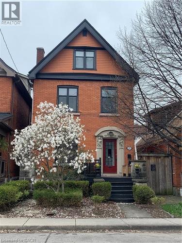 Brick exterior with black trim and a gabled roofline - 207 Charlton Avenue W, Hamilton, ON 