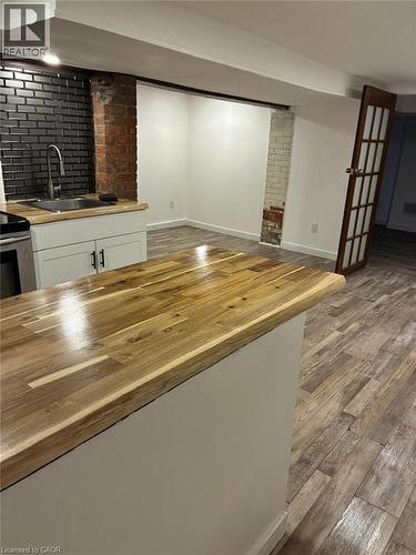Wood-finish flooring throughout, with a wood-finish countertop on the kitchen island - 207 Charlton Avenue W, Hamilton, ON 