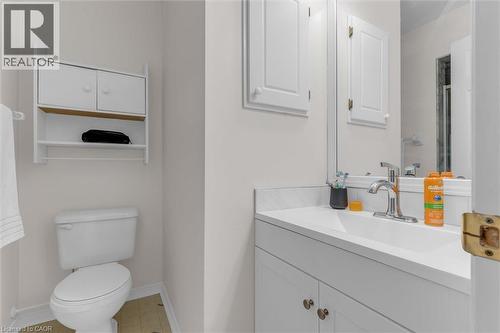 Bathroom featuring a white vanity with an integrated sink, polished chrome faucet, and a large mirror - 149 Silverbirch Boulevard, Hamilton, ON 