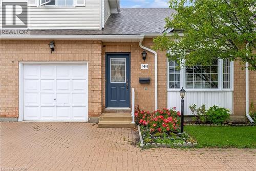 Brick exterior featuring a paneled garage door and paver driveway - 149 Silverbirch Boulevard, Hamilton, ON 