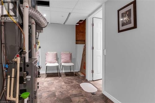 Utility area with durable flooring, neutral wall tones, white trim, and a paneled interior door - 149 Silverbirch Boulevard, Hamilton, ON 