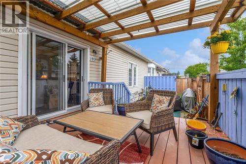 Covered deck featuring wood-finish flooring and a translucent corrugated roof - 149 Silverbirch Boulevard, Hamilton, ON 