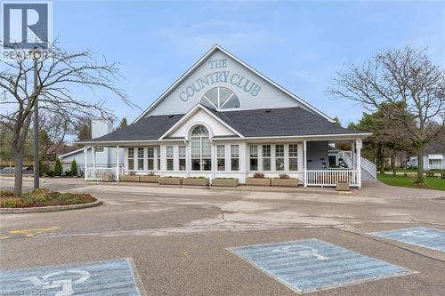 Gable-roofed building featuring white siding and a prominent ""THE COUNTRY CLUB"" inscription - 149 Silverbirch Boulevard, Hamilton, ON 