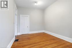 Interior room featuring wood-finish flooring, light gray walls, and white trim - 