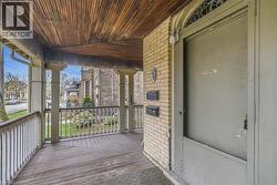 Covered porch featuring a wood-finish ceiling, wood-finish flooring, and a decorative railing - 