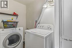 Dedicated laundry area featuring a built-in shelf, overhead lighting, and white walls - 