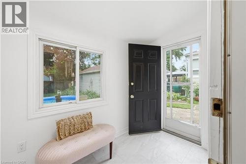 Entryway featuring a paneled door, storm door, and a sliding window with trim - 81 Vale Avenue, St. Catharines, ON 
