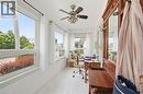 Sunlit room featuring multiple windows, a ceiling fan, and wood-finish flooring - 81 Vale Avenue, St. Catharines, ON 