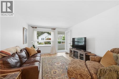 Living area featuring light wood-finish flooring, white walls, and a large window with white blinds - 81 Vale Avenue, St. Catharines, ON 