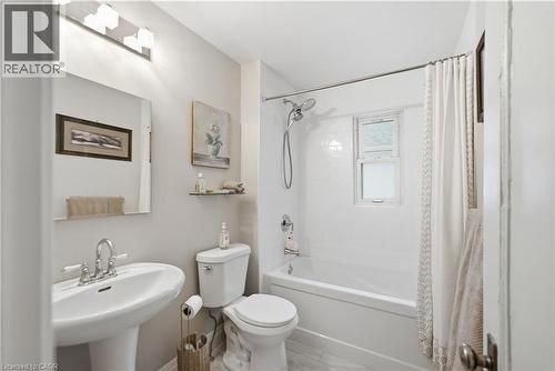 Bathroom featuring a pedestal sink, a toilet, and a bathtub with white subway tile surround - 81 Vale Avenue, St. Catharines, ON 