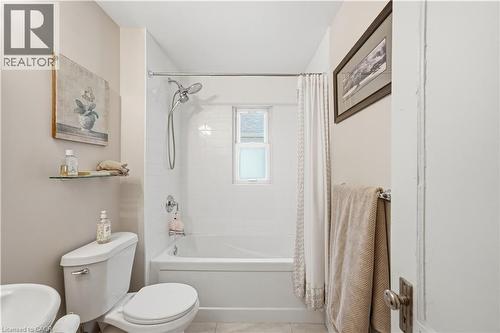 Bathroom featuring a white subway tile shower surround with a built-in window, a chrome showerhead, and a matching tub - 81 Vale Avenue, St. Catharines, ON 