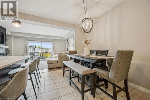 Open concept living area with tiled flooring, recessed lighting, and a contemporary spherical chandelier - 907 Robert Ferrie Drive, Kitchener, ON 