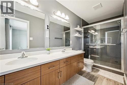 Modern bathroom featuring a dual vanity with wood-finish cabinetry and a white countertop - 907 Robert Ferrie Drive, Kitchener, ON 