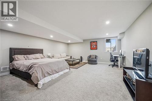 Spacious carpeted room featuring recessed lighting, a window, and light gray walls - 907 Robert Ferrie Drive, Kitchener, ON 