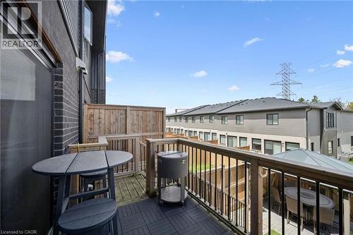 Outdoor balcony featuring composite decking, wood railing with black metal balusters, and privacy fencing - 907 Robert Ferrie Drive, Kitchener, ON 