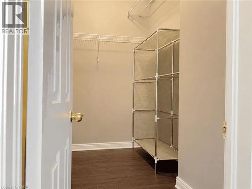 Walk-in closet featuring wood-finish flooring, light tan walls, and white baseboard trim - 78 Colton Circle, Kitchener, ON 