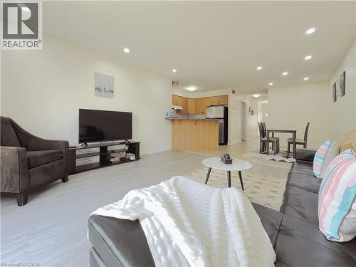 Expansive living area featuring recessed lighting, light wood-finish flooring, and a breakfast bar with granite-style countertops - 78 Colton Circle, Kitchener, ON 