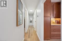 Hallway with wood-finish flooring, recessed lighting, and white walls - 