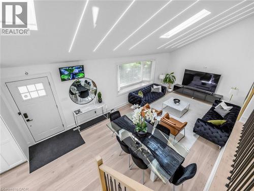 Open-concept living and dining area featuring light wood-finish flooring, a vaulted ceiling with integrated linear lighting, and a large skylight - 13 Swanhurst Boulevard, Mississauga, ON 