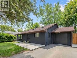Contemporary exterior featuring dark gray siding and a brown shingle roof - 
