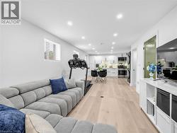 loweer level living space featuring wood-finish flooring, recessed lighting, and white walls - 