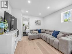 lower level living area featuring light wood-finish flooring, white walls, and recessed lighting - 